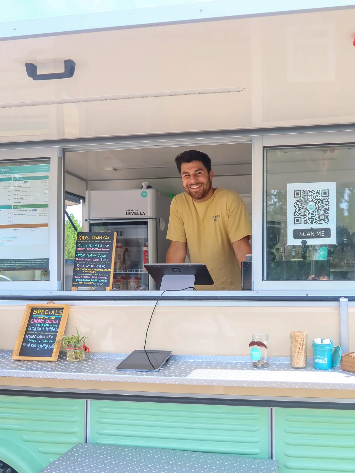 Zack Bennett, founder of Common Tides Coffee, and his fiancée in the doorway of their vintage mobile espresso trailer in Wilmington NC